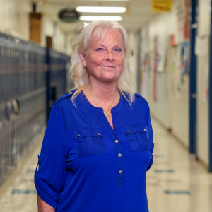 Brandywine's Patricia Werley stands smiling in a school hallway.