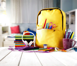 Image of a yellow book bag and school supplies